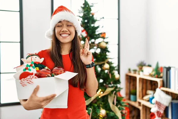 Young Brunette Woman Standing Christmas Tree Holding Decoration Gesturing Finger — Fotografia de Stock
