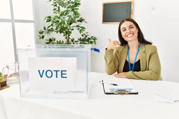 Jonge Brunette Vrouw Zit Aan Verkiezingstafel Met Stembiljet Glimlachend Doen — Stockfoto