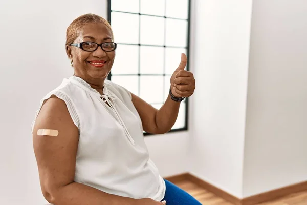 Mature Hispanic Woman Getting Vaccine Showing Arm Band Aid Approving — Stockfoto