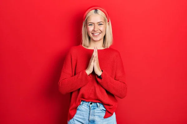 Beautiful Blonde Woman Wearing Casual Red Sweater Praying Hands Together — ストック写真