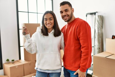 Genç İspanyol çift gülümsüyor mutlu bir şekilde yeni evin anahtarını tutuyor..
