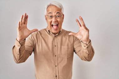 İspanyol kıdemli gözlüklü çılgın ve başarıyı kutlayan kolları açık, gözleri açık heyecanlı bir şekilde haykıran gözlüklü adam. Kazanan konsept 