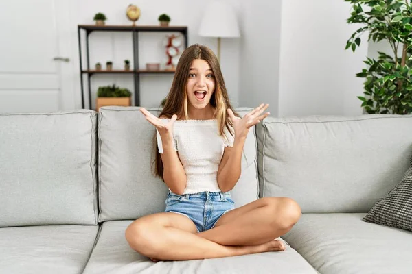 Young Brunette Teenager Sitting Sofa Home Celebrating Crazy Amazed Success — Zdjęcie stockowe