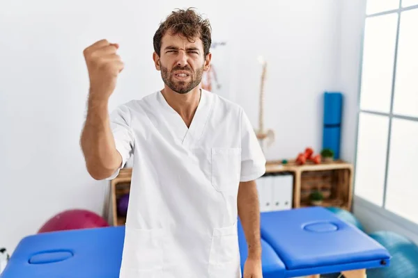 Young Handsome Physiotherapist Man Working Pain Recovery Clinic Angry Mad — Stock Photo, Image