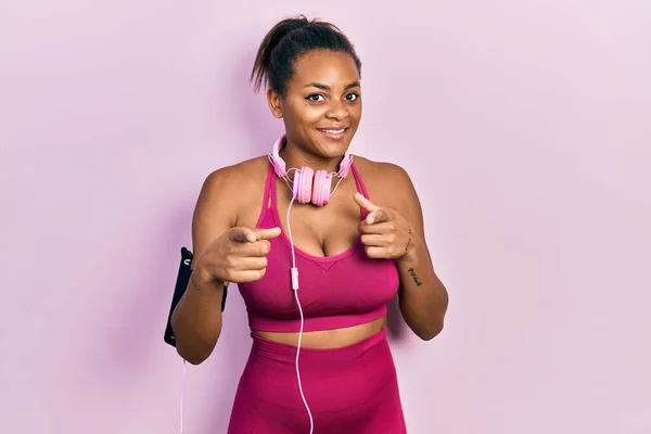 Young African American Girl Wearing Gym Clothes Using Headphones Pointing — ストック写真