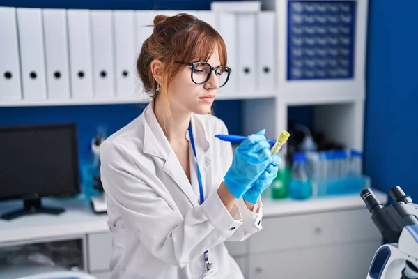 Young woman scientist write on test tube at laboratory