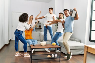 Mutlu bir şekilde gülümseyen ve dans eden bir grup genç arkadaş..