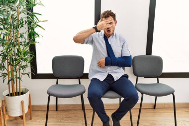 Yakışıklı genç adam, doktor bekleme odasında kolundan yaralanmış bir şekilde oturuyor. Şoka girmiş, yüzünü ve gözlerini kapamış, utanmış bir ifadeyle parmaklarından bakıyor.. 