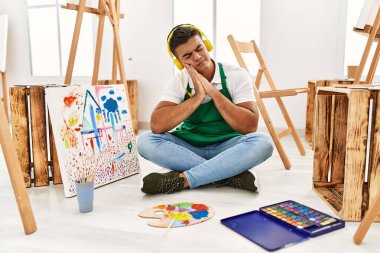 Sanat stüdyosunda uyuyan genç İspanyol adam yorgun düşler görüyor ve elleri ile poz verirken gözleri kapalı gülümsüyor.. 