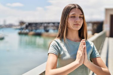 Deniz kenarında dua eden sevimli kız.