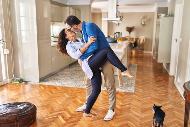 Orta yaşlı İspanyol çift evde öpüşüyor ve dans ediyor.