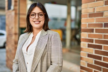 Genç İspanyol iş kadını şehirde mutlu mesut ayakta duruyor..