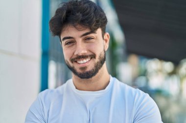 Sokakta kendinden emin gülümseyen İspanyol genç adam.