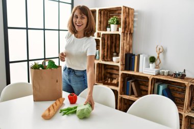 Kafkasyalı genç bir kadın elinde alışveriş poşeti tutuyor.