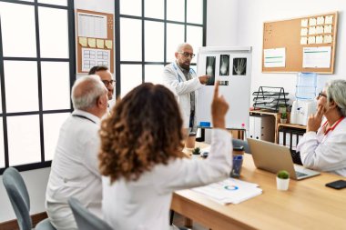 Bir grup orta yaşlı doktor klinikteki bir tıbbi toplantıda tartışıyorlar..