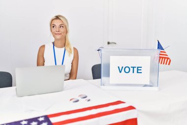 Young caucasian woman at america political campaign election smiling looking to the side and staring away thinking. 