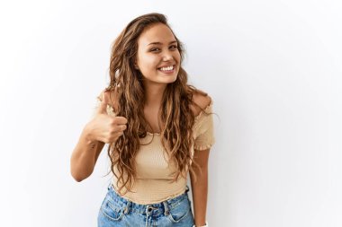 Güzel İspanyol kadın, arka planda mutlu bir jest yaparken tek başına ayakta duruyor. Kameraya bakıp başarıyı gösteren ifade. 