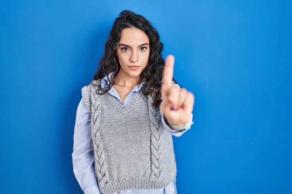 Jonge Brunette Vrouw Staande Blauwe Achtergrond Wijzend Met Vinger Omhoog — Stockfoto