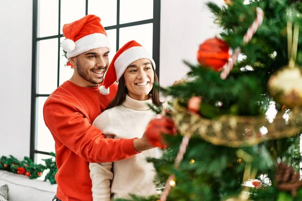 Genç Spanyol Çift Gülümsüyor Mutlu Noel Ağacı Süslüyor Evde — Stok fotoğraf