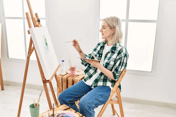 Young artist student girl smiling happy painting at art studio.