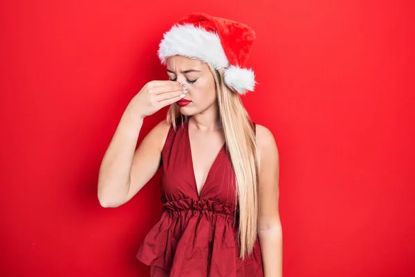 年轻的金发女郎戴着圣诞礼帽 疲惫地揉揉鼻子和眼睛 感到疲倦和头痛 压力和挫败感概念 — 图库照片