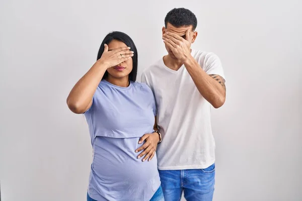 Young Hispanic Couple Expecting Baby Standing Background Covering Eyes Hand — Stock Photo, Image