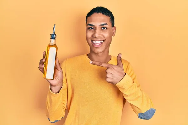 Jong Afrikaans Amerikaans Guy Holding Olijfolie Kan Glimlachen Gelukkig Wijzend — Stockfoto