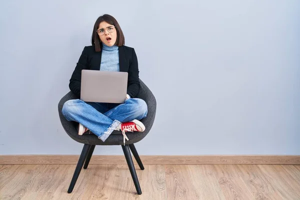 Young Hispanic Woman Sitting Chair Using Computer Laptop Shock Face — Stock fotografie