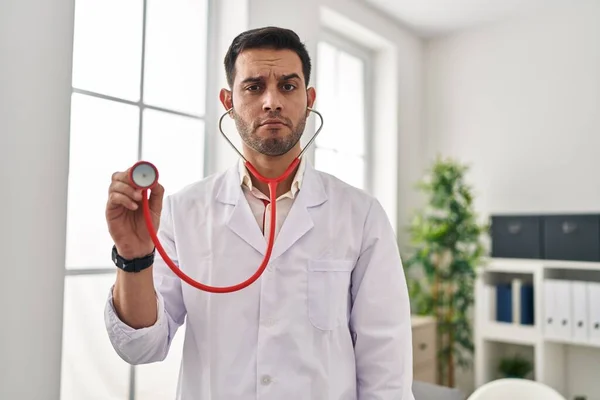 Young Hispanic Doctor Man Beard Holding Stethoscope Auscultating Depressed Worry — 스톡 사진