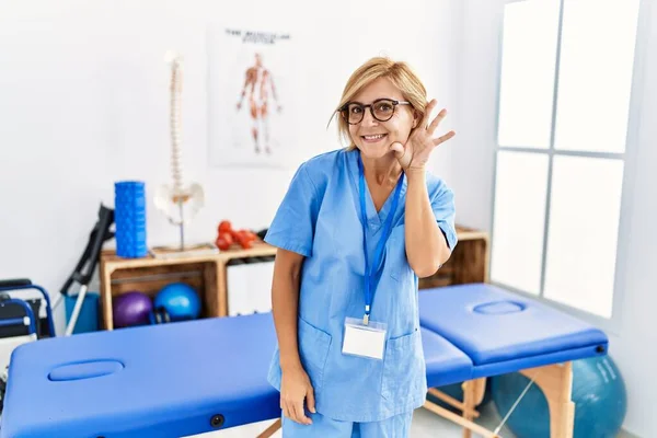Middle Age Blonde Woman Working Pain Recovery Clinic Smiling Hand — Stockfoto