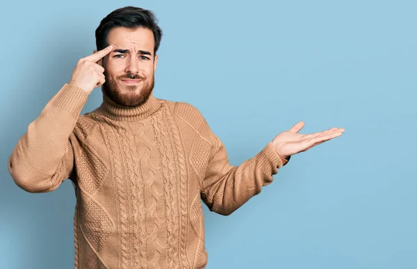 Gündelik giysiler giyen genç İspanyol adam avuç içi açık fotokopi alanı gösterip alnını işaret etmekten rahatsız oluyor. Bunu bir düşün.. 