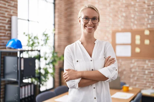 Young blonde woman business worker standing with arms crossed gesture at office