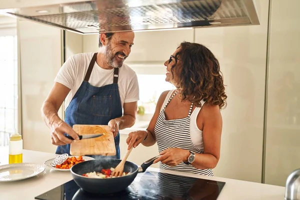 Casal Hispânico Meia Idade Sorrindo Confiante Derramando Comida Frigideira Cozinha — Fotografia de Stock
