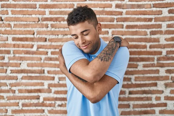 Brazilian Young Man Standing Brick Wall Hugging Oneself Happy Positive — Stock Photo, Image