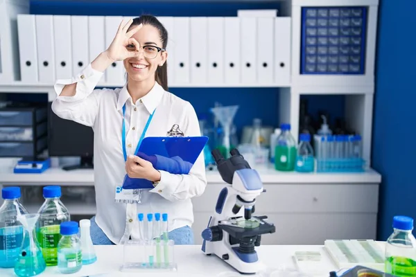 Young Brunette Woman Working Scientist Laboratory Doing Gesture Hand Smiling — ストック写真