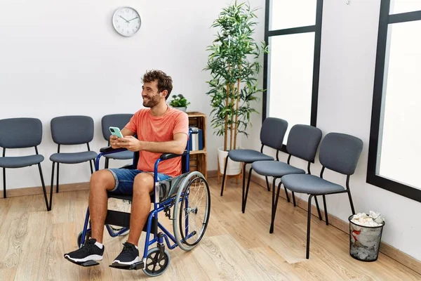 Mladý Hispánec Pomocí Smartphone Sedí Invalidním Vozíku Klinice Čekárna — Stock fotografie