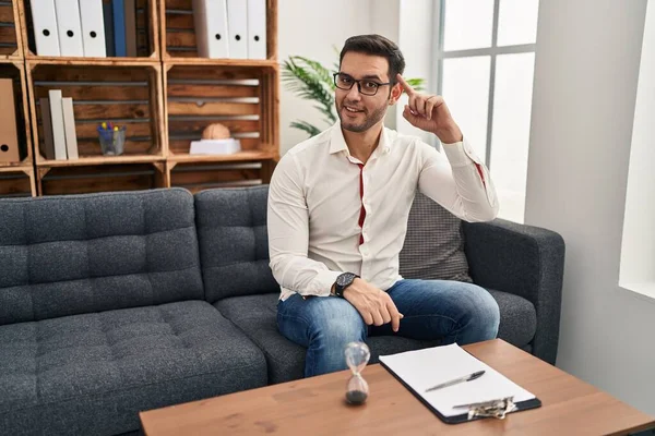 Young Hispanic Man Beard Working Consultation Office Smiling Pointing Head — Stockfoto