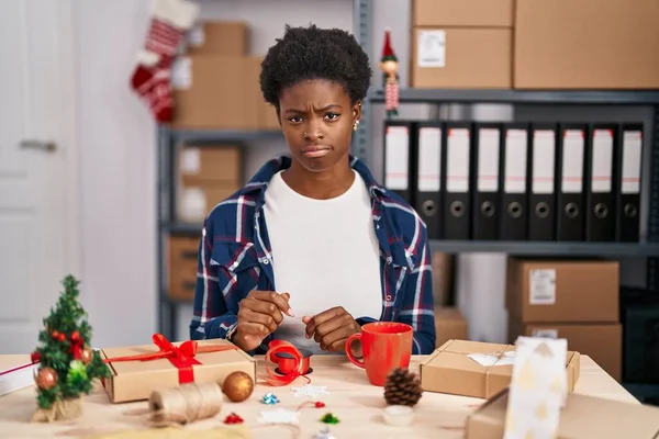 African american woman working at small business doing christmas decoration skeptic and nervous, frowning upset because of problem. negative person.