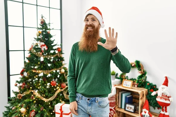 Redhead Man Long Beard Wearing Christmas Hat Christmas Tree Showing — 图库照片