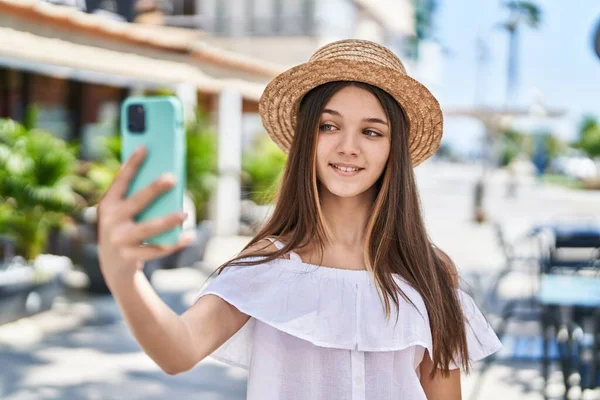 Adorable girl tourist smiling confident make selfie by the smartphone at street
