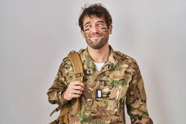 Hispanic Young Man Wearing Camouflage Army Uniform Smiling Looking Side – stockfoto