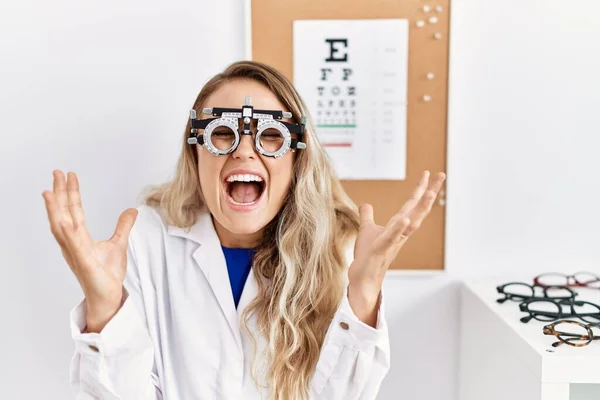 Young Beautiful Optician Woman Wearing Optometry Glasses Clinic Celebrating Mad — Stok fotoğraf