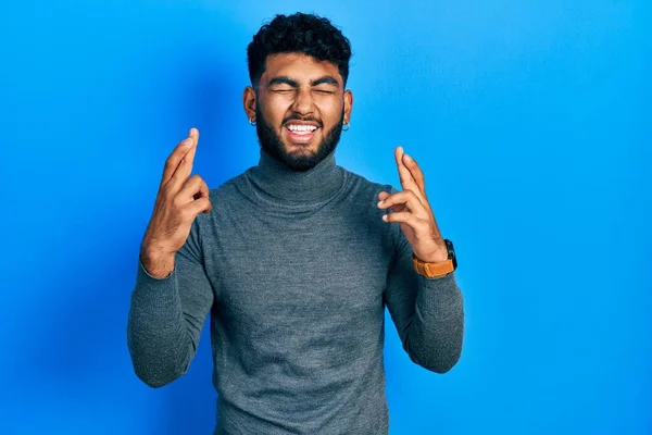 Arab Man Beard Wearing Turtleneck Sweater Gesturing Finger Crossed Smiling — Stockfoto