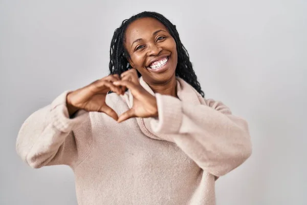 African Woman Standing White Background Smiling Love Doing Heart Symbol — стоковое фото