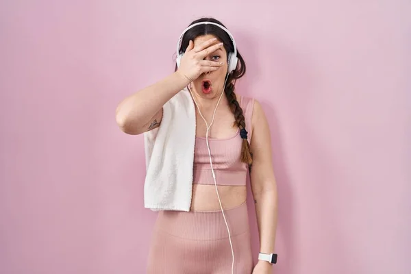 Young Brunette Woman Wearing Sportswear Headphones Peeking Shock Covering Face — Stock Photo, Image