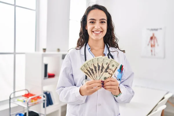 Mujer Doctora Joven Sosteniendo Dinero Sonriendo Con Una Sonrisa Alegre —  Fotos de Stock