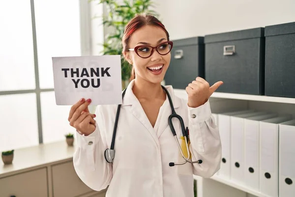 Young Caucasian Woman Wearing Doctor Uniform Holding Thank You Banner — Foto Stock