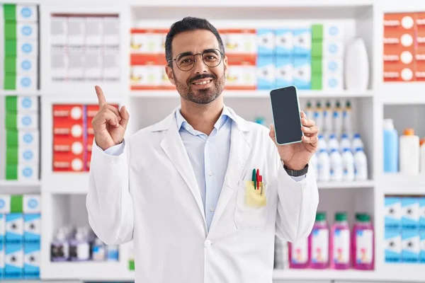 Hispanic Man Beard Working Pharmacy Drugstore Showing Smartphone Screen Smiling — Stock Photo, Image