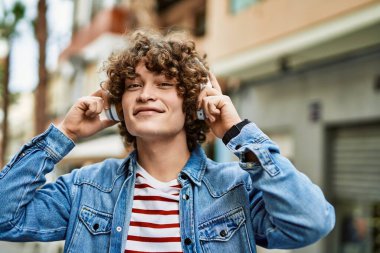 Şehirde kulaklık takıp müzik dinleyen genç bir İspanyol.
