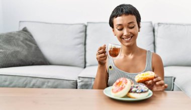 Genç İspanyol kadın evde kahvaltı ederken kendine güler yüzlü.